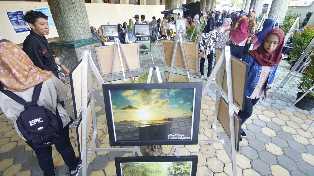 Beberapa mahasiswa menikmati foto karya mahasiswa Bahasa Indonesia dalam Gelar Karya Bahtera, Jumat 